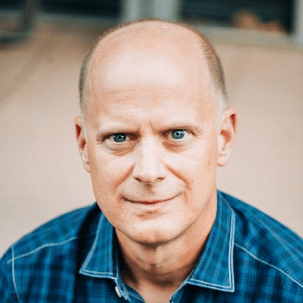Portrait of Jim Szafranski wearing a blue plaid shirt.